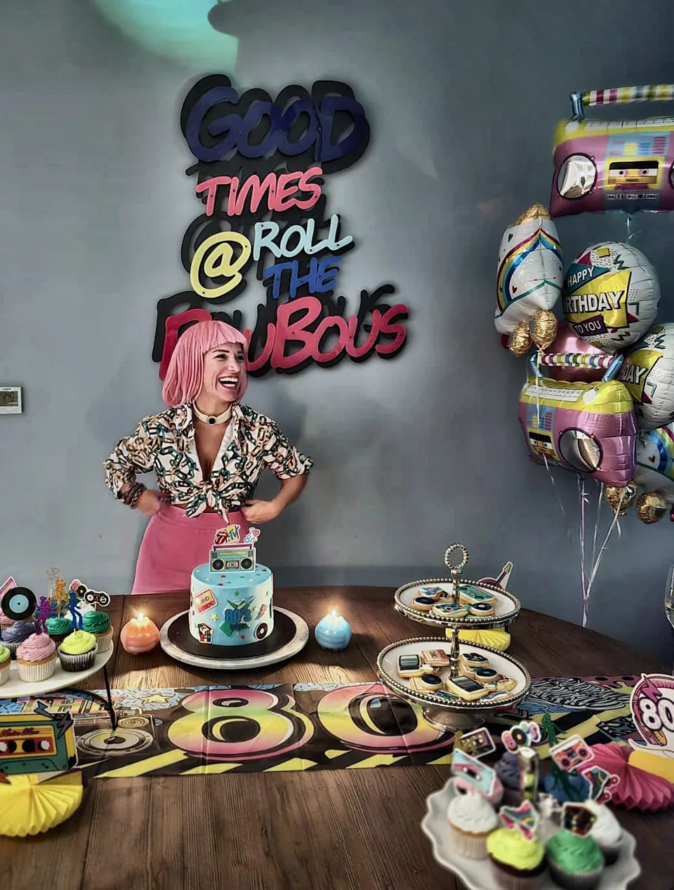Eighties birthday party with a Good Times neon sign, a retro cake and colourful treats