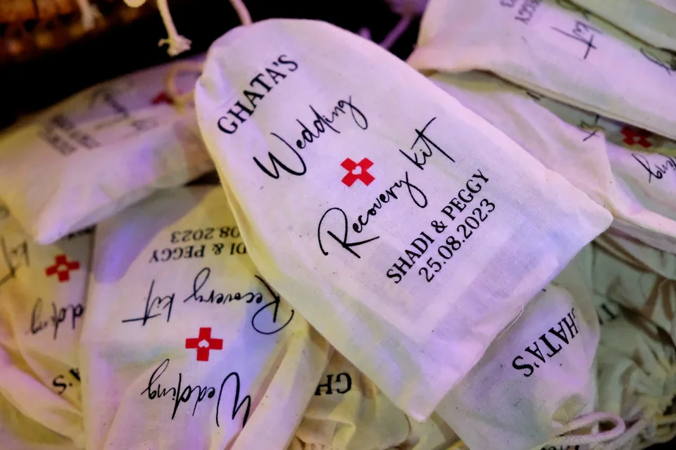 Personalised wedding recovery kit bags printed with the couple's names and date