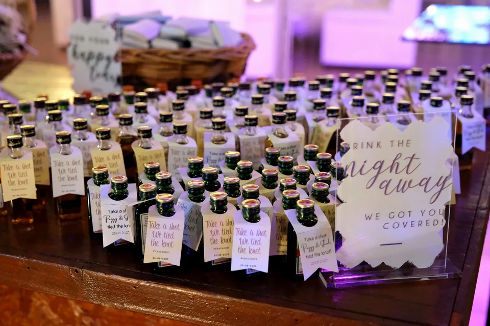 Personalised mini bottle favours beside a Drink the Night Away sign
