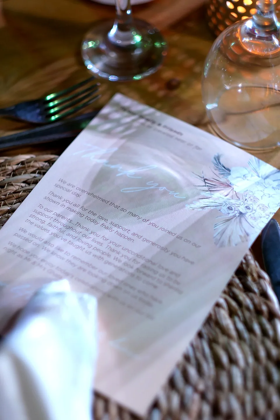 Printed personalised wedding note on a woven place mat beside a glass