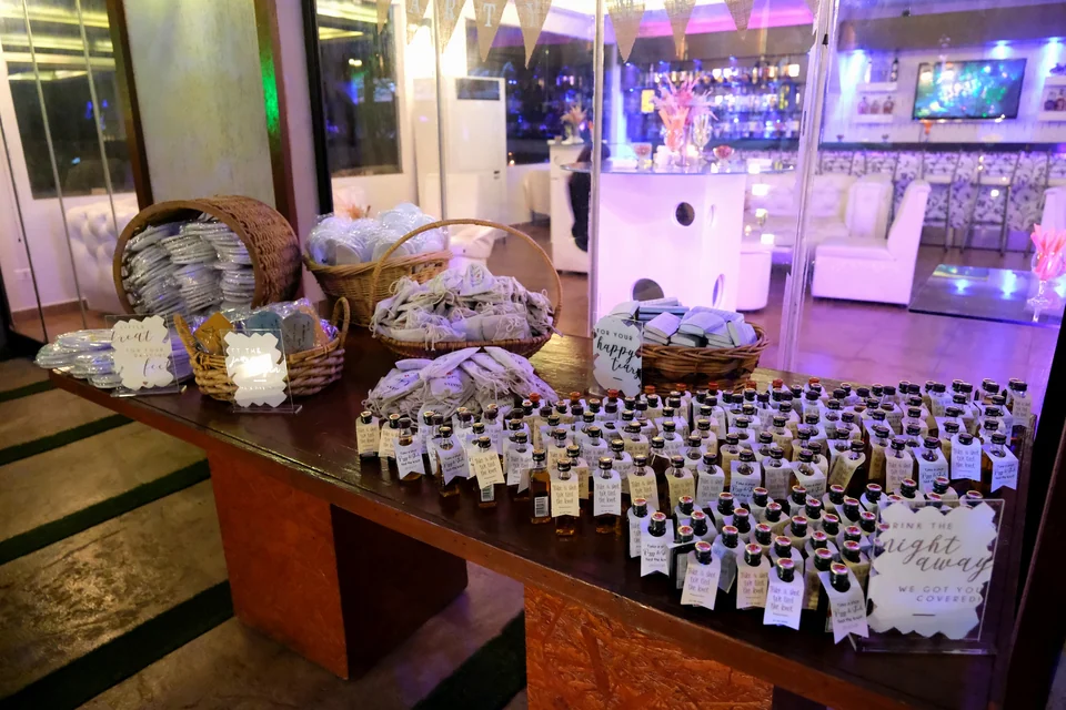 Wedding favour table with woven baskets and rows of personalised mini bottles