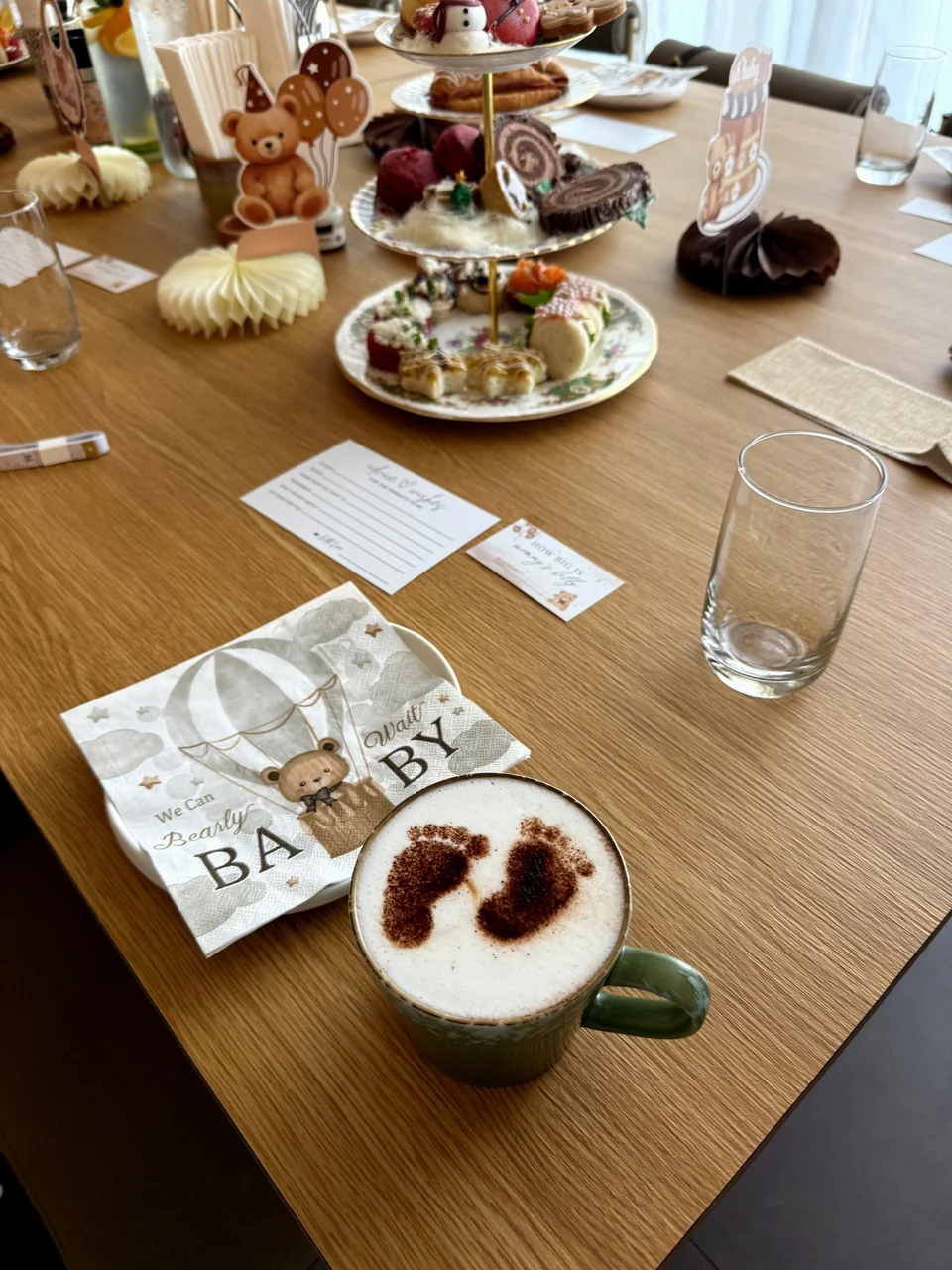 Baby shower table with a footprint latte, a hot air balloon napkin and tiered stands of treats