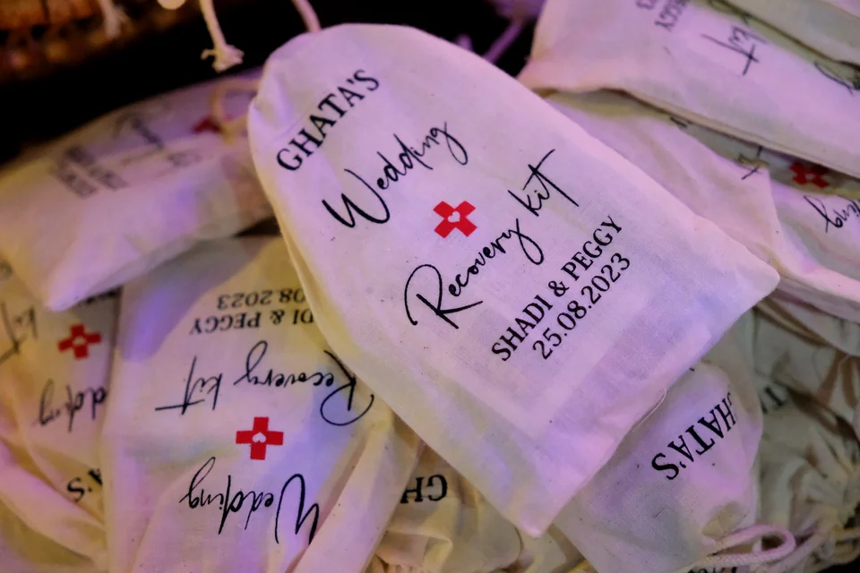 Personalised wedding recovery kit bags printed with the couple's names and date