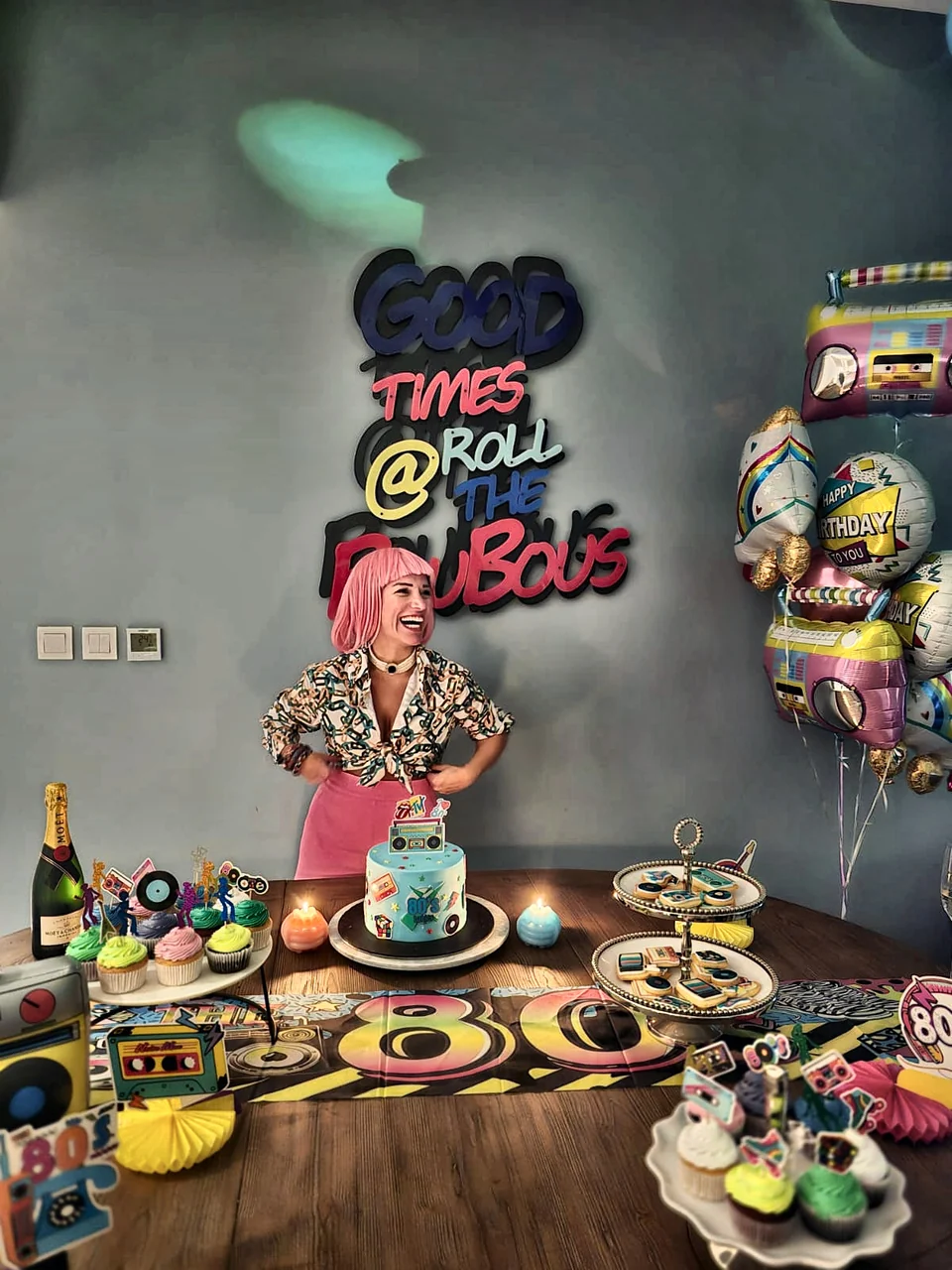 Eighties themed birthday with a Good Times Roll neon sign, retro balloons and a decorated cake