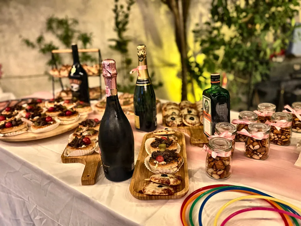 Bachelorette table set with bottles of bubbly, desserts and jars of treats