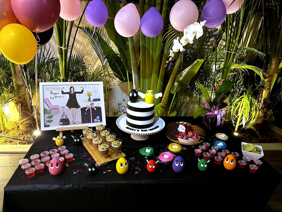 Egg Shower dessert table with a striped cake and colourful eggs