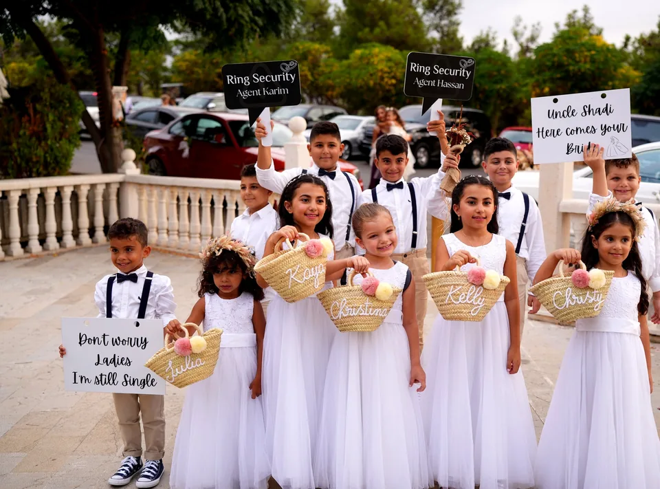 Flower girls and page boys holding personalised straw baskets and Ring Security signs at our wedding